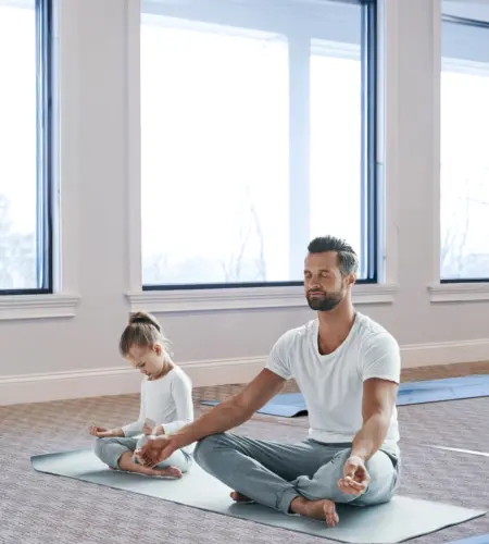 Father and child meditating during Daddy and Me Yoga at The Preserve Spa.